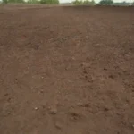 Paisaje urbano con suelo contaminado siendo tratado utilizando diversas técnicas y equipos de rehabilitación.